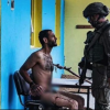 Soldat israelian care interoghează un palestinian dezbrăcat, legat la mâini și plin de sânge. Experți juridici: „Rele tratamente aplicate prizonierilor”