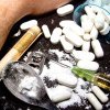 DIICOT: Peste 440.000 de comprimate cu droguri și 25 de cartușe, găsite în locuința unui traficant