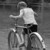 Redescoperind trecutul: Nu mulți pot înțelege această fotografie! Vremurile când copiii de pe o stradă întreagă împărțeau o bicicletă au apus- FOTO